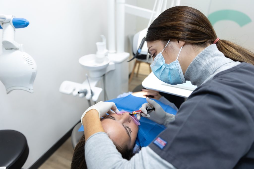 Dentista aplicando tratamiento bucal a una paciente