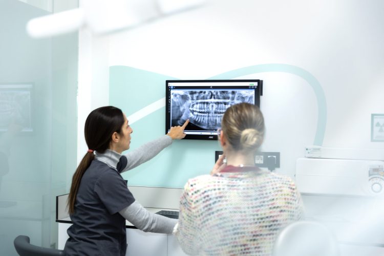Quality Dental Martorell - Dentista revisando radiografia con paciente
